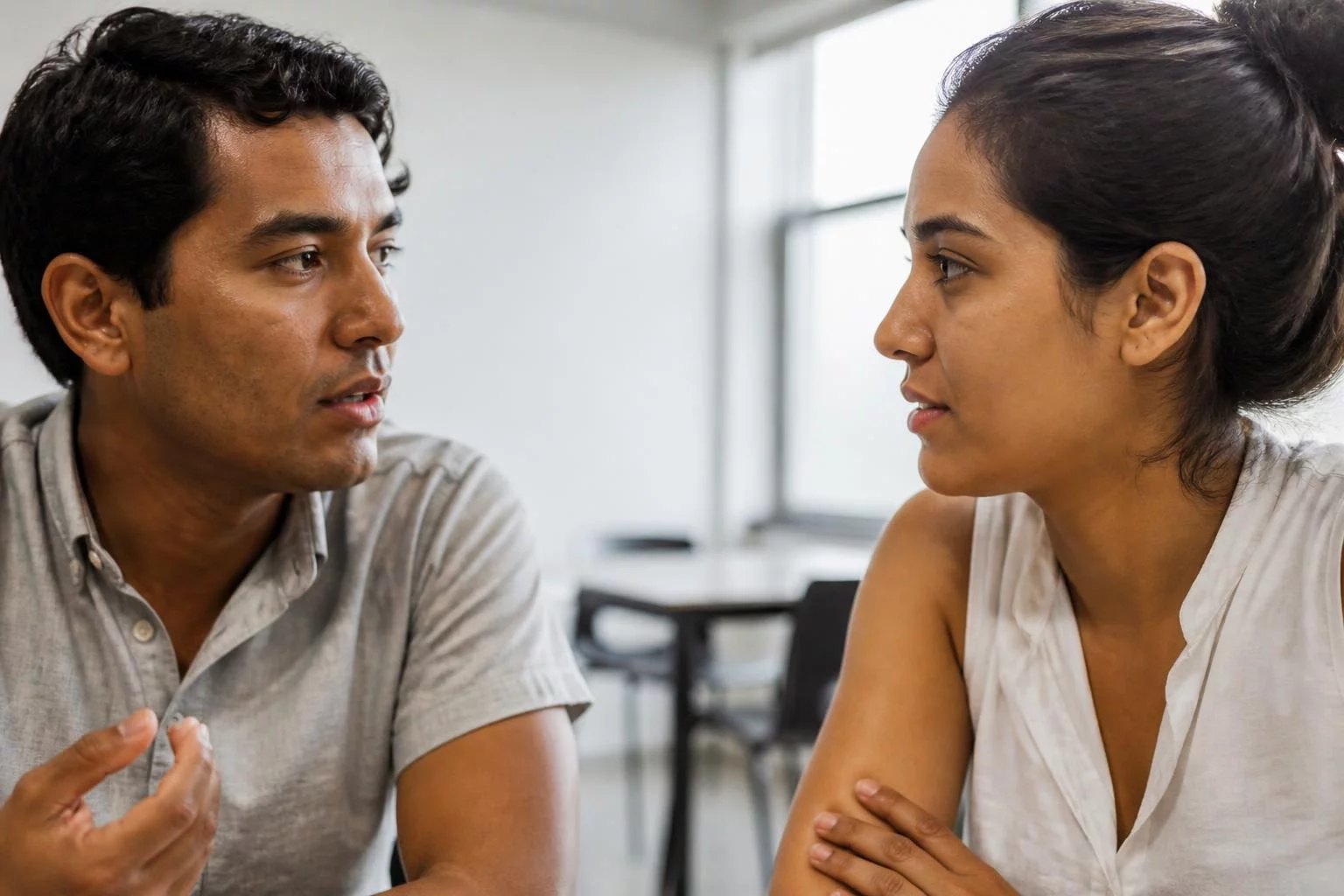 Dos personas sentadas una junto a otra, discutiendo un punto